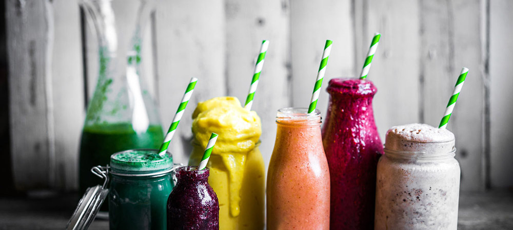 Variety of colorful smoothies on rustic wooden background