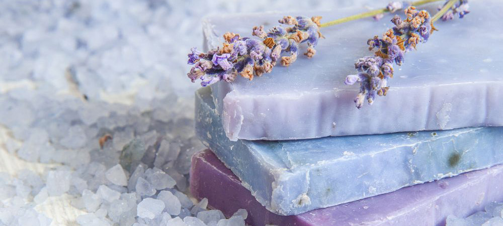 Natural soap, lavender, salt on a wooden board, hygiene items for bath and spa.