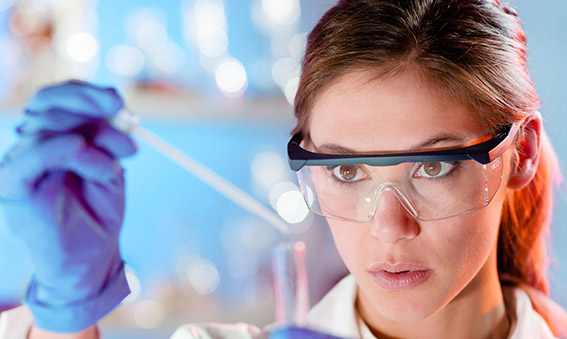 Attractive young scientist pipetting.